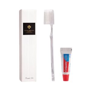 Vittore De Conti dental set featuring a transparent toothbrush, Colgate toothpaste, and elegant packaging. Essential guest amenities.