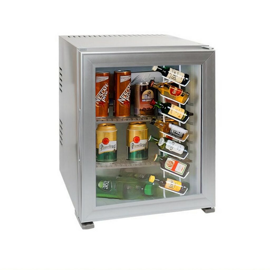 Hotel room minibar fridge, 30 liters, silver color and glass transparent door, stylish, stocked with soft drinks, beers, and miniature liquor bottles. A luxury hotel room appliance for guest comfort and convenient access to refreshments, enhancing overall hotel amenities.