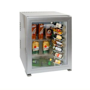 Hotel room minibar fridge, 30 liters, silver color and glass transparent door, stylish, stocked with soft drinks, beers, and miniature liquor bottles. A luxury hotel room appliance for guest comfort and convenient access to refreshments, enhancing overall hotel amenities.