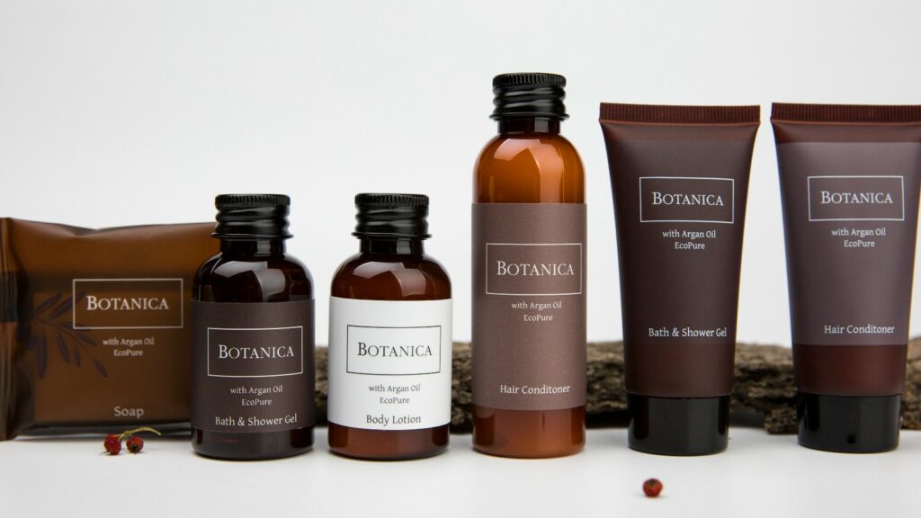 Display of Botanica hotel toiletries brand with elegant sleek tubes, sleek bottles and soap wrapped in an luxurious bag, offering guests natural and indulgent hotel amenities.